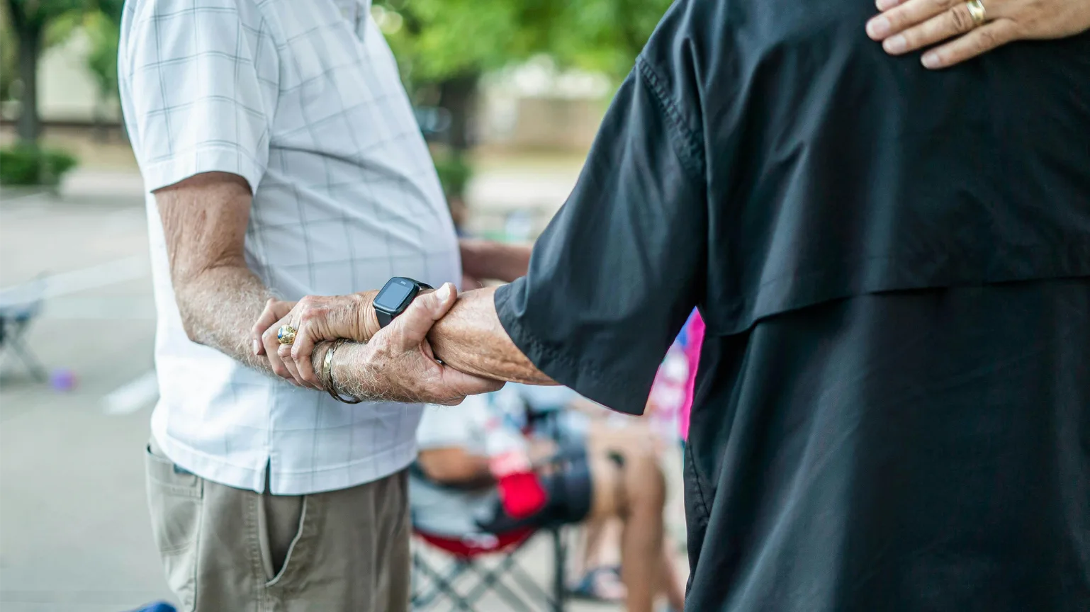 Two people holding hands in a moment of support.